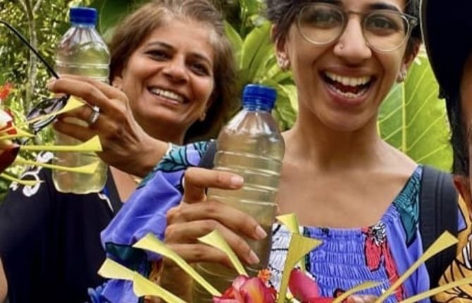 Guests proudly holding bottles of homemade coconut oil in Bali